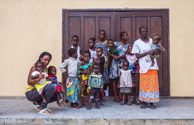 Bambini e volontari dell'Associazione Madre Teresa di Calcutta Onlus posano davanti all'ingresso della mensa di Kinshasa
